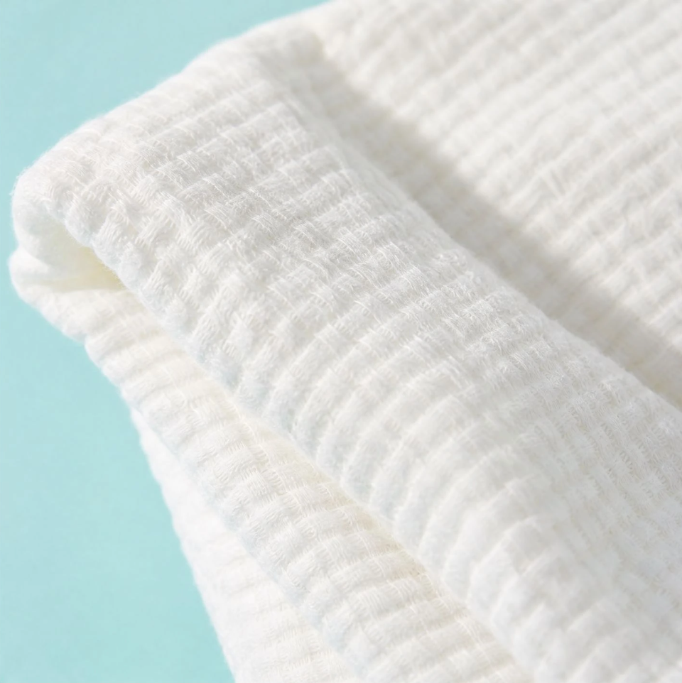 Close-up macro of the soft textured Sleepgram Luxe Towel weave on a turquoise background