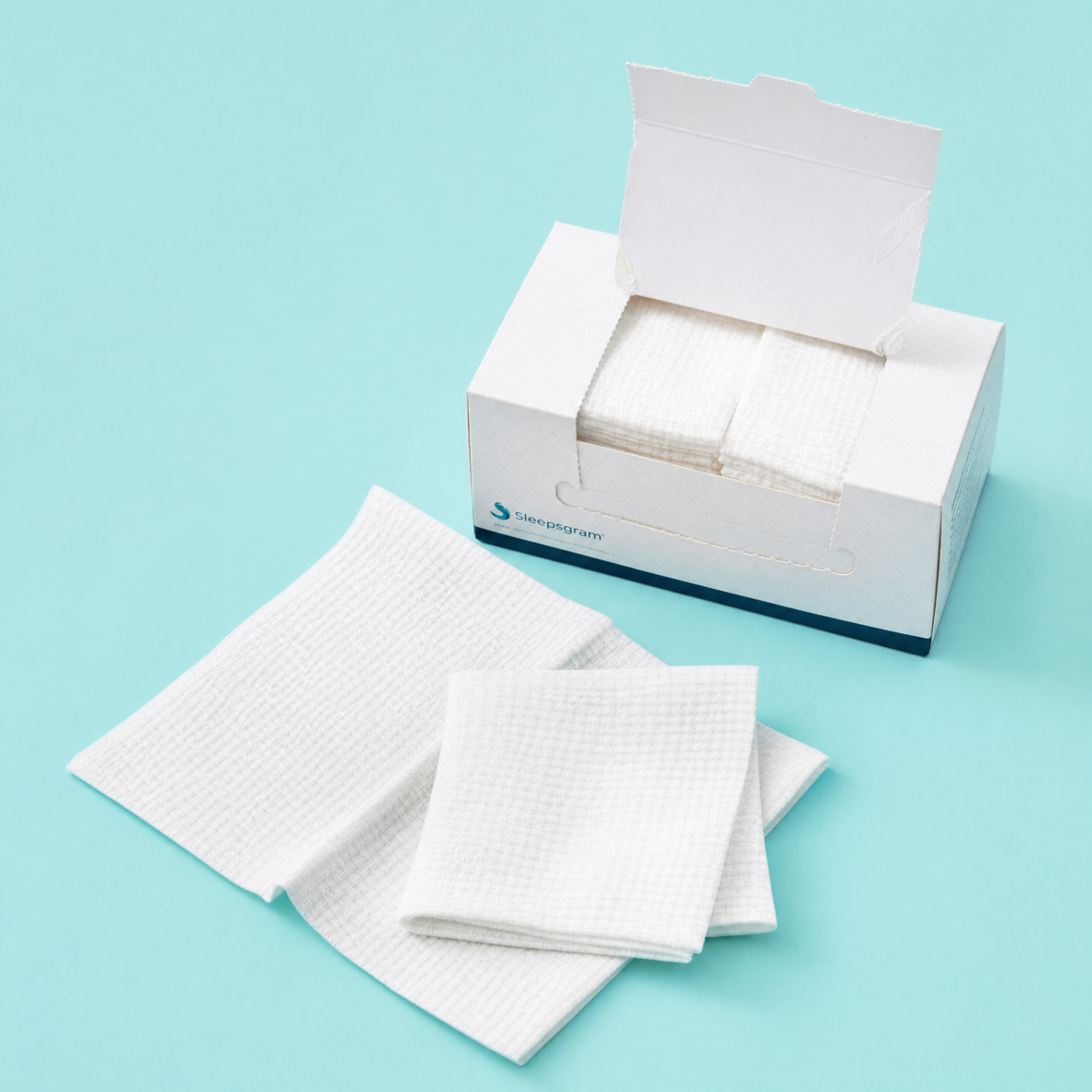Open Sleepgram towel box with folded facial towels displayed on a turquoise background